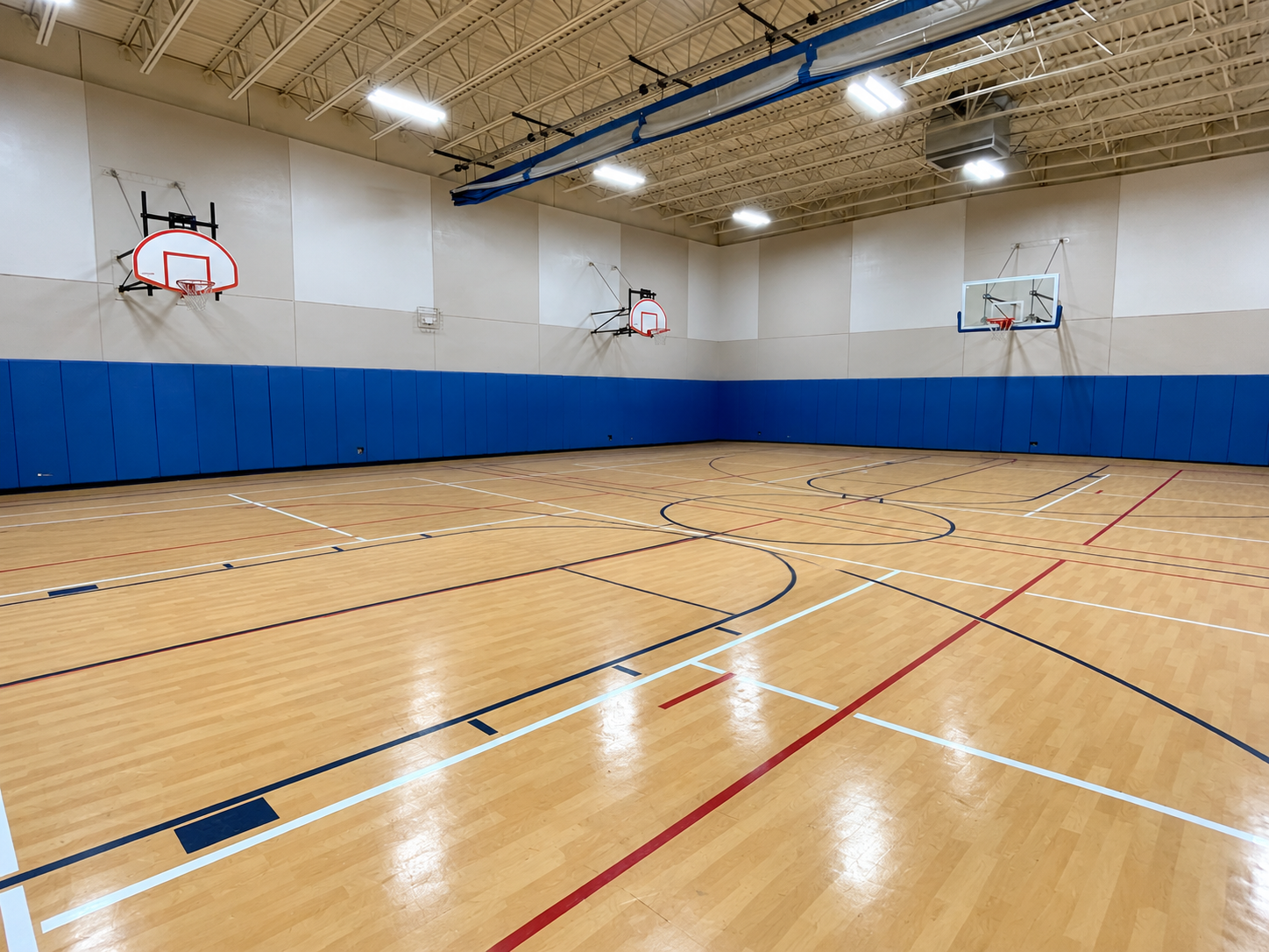 Hardwood court with wall padding at the Oak Brook Terrace gym